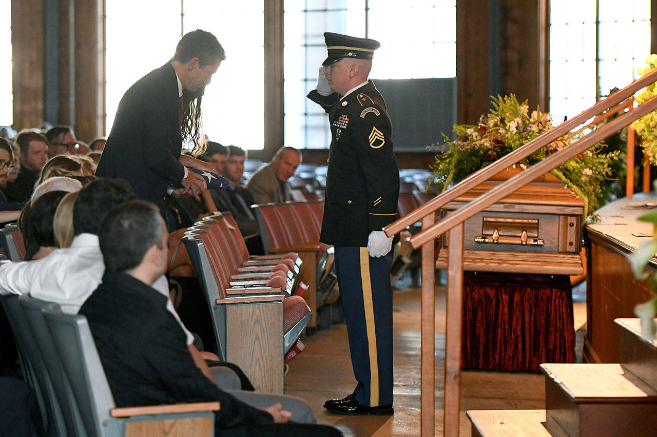 Thomas Howell and Natalie Henry-Howell, parents of Riley Howell, are saluted by a military honor guard after receiving his flag during a memorial service for their son in Lake Junaluska, North Carolina, on Sunday. (AP Photo/Kathy Kmonicek)