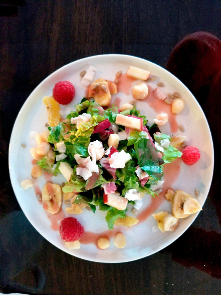 The “Dreaming of Vacation” salad at Crow Island Farms is a plate of mixed greens topped with a summery assortment of banana chips, coconut shavings, dried kiwi, raspberries, apples, macadamia nuts and sunflower seeds, and dressed with a strawberry vinaigrette. (Pam Bruestle)
