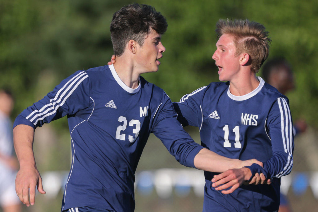 Meadowdale’s Stephen Koon (right) congratulates River Stewart (left) for his goal against Edmonds-Woodway during a 3A district semifinal on May 7, 2019, at Shoreline Stadium. (Kevin Clark / The Herald)
