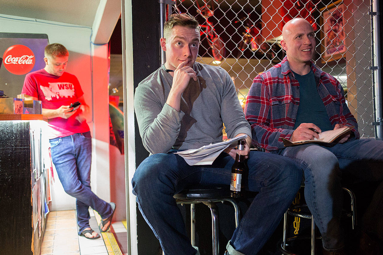 Kyle Hackbarth (left) and Verlon Roberts listen to other comics as they prepare notes at the Comedy Garage. (Andy Bronson / The Herald)