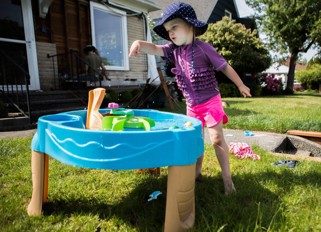 Thea Reece, 3, plays with a water toy in her family’s front yard on Thursday in Everett. (Olivia Vanni / The Herald)
