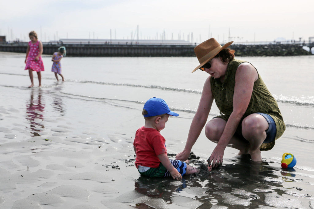 Barb Parnell (right) plays with Gage Tinker on Sunday afternoon at Olympic Beach in Edmonds. (Kevin Clark / The Herald)
