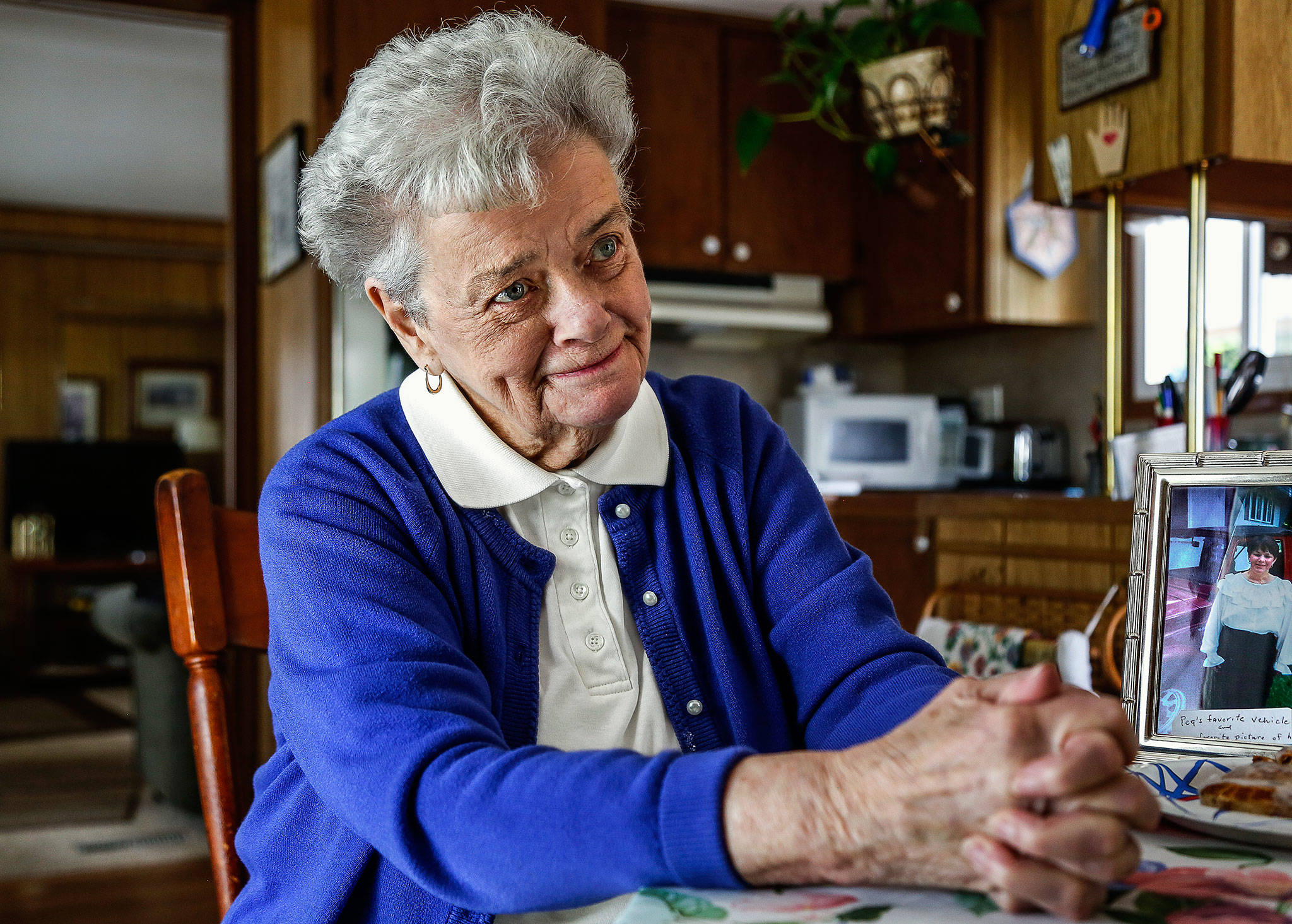 At 85, some challenges come every day. On a particularly tough day, Everett’s Patricia Browning says she met “angels” who helped her through. One was a young man who changed her tire and graciously refused payment. Browning, who lost her daughter Peggy Strain (in photo on table) to cancer Friday, remains a believer in goodness. (Dan Bates / The Herald)