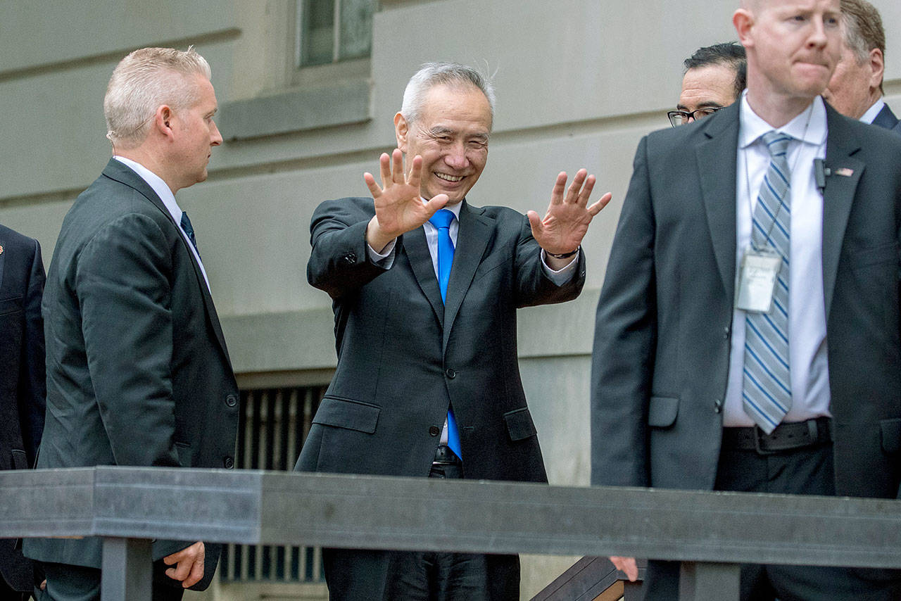 Chinese Vice Premier Liu He waves to members of the media as he arrives at the Office of the United States Trade Representative in Washington on Friday for trade talks between the United States and China. (AP Photo/Andrew Harnik)