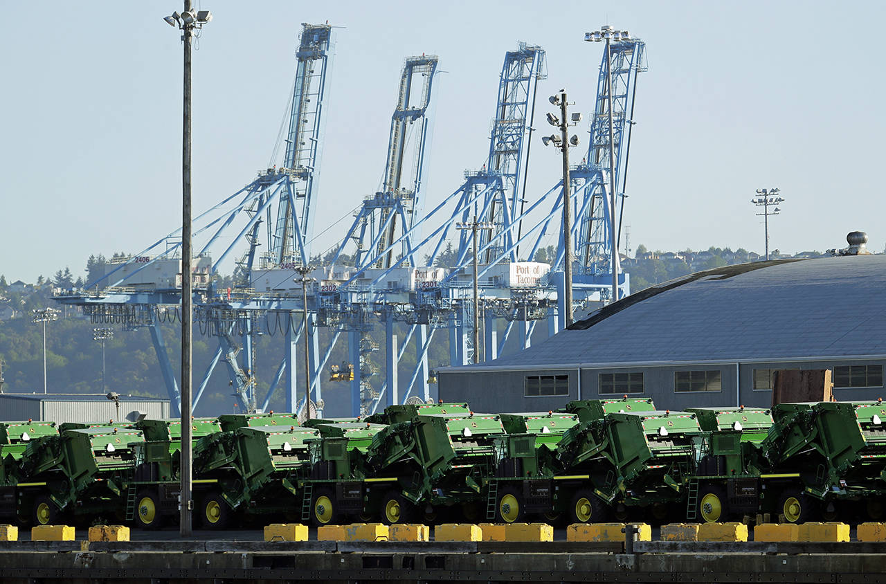 John Deere Agricultural machinery made by Deere & Company sits staged for transport Friday, near cranes at the Port of Tacoma. U.S. and Chinese negotiators resumed trade talks Friday under increasing pressure after President Donald Trump raised tariffs on $200 billion in Chinese goods and Beijing promised to retaliate. (AP Photo/Ted S. Warren)