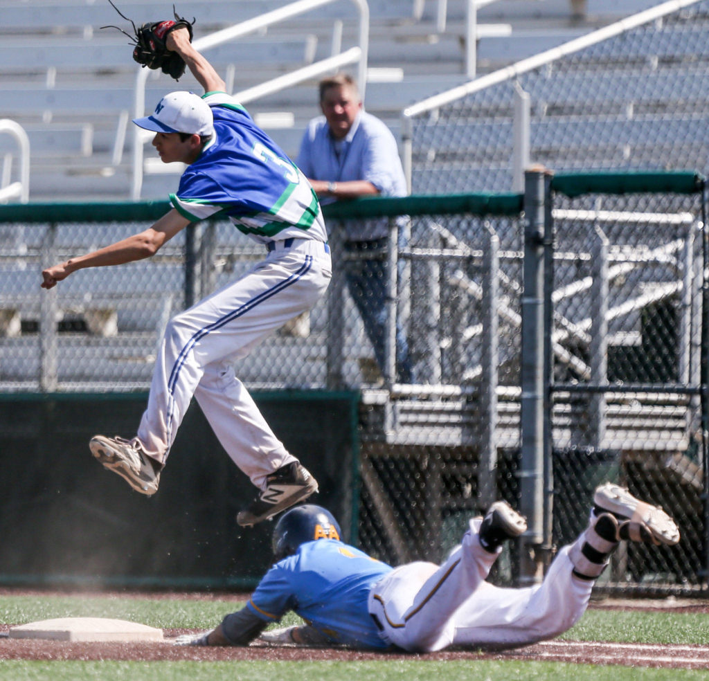 Everett’s Tyler Bates slides into first under Shorewood’s Kenji Miller during the 3A District 1 Tournament championship game on May 11, 2019, at Funko Field at Everett Memorial Stadium. The Seagulls won 6-0. (Kevin Clark / The Herald)
