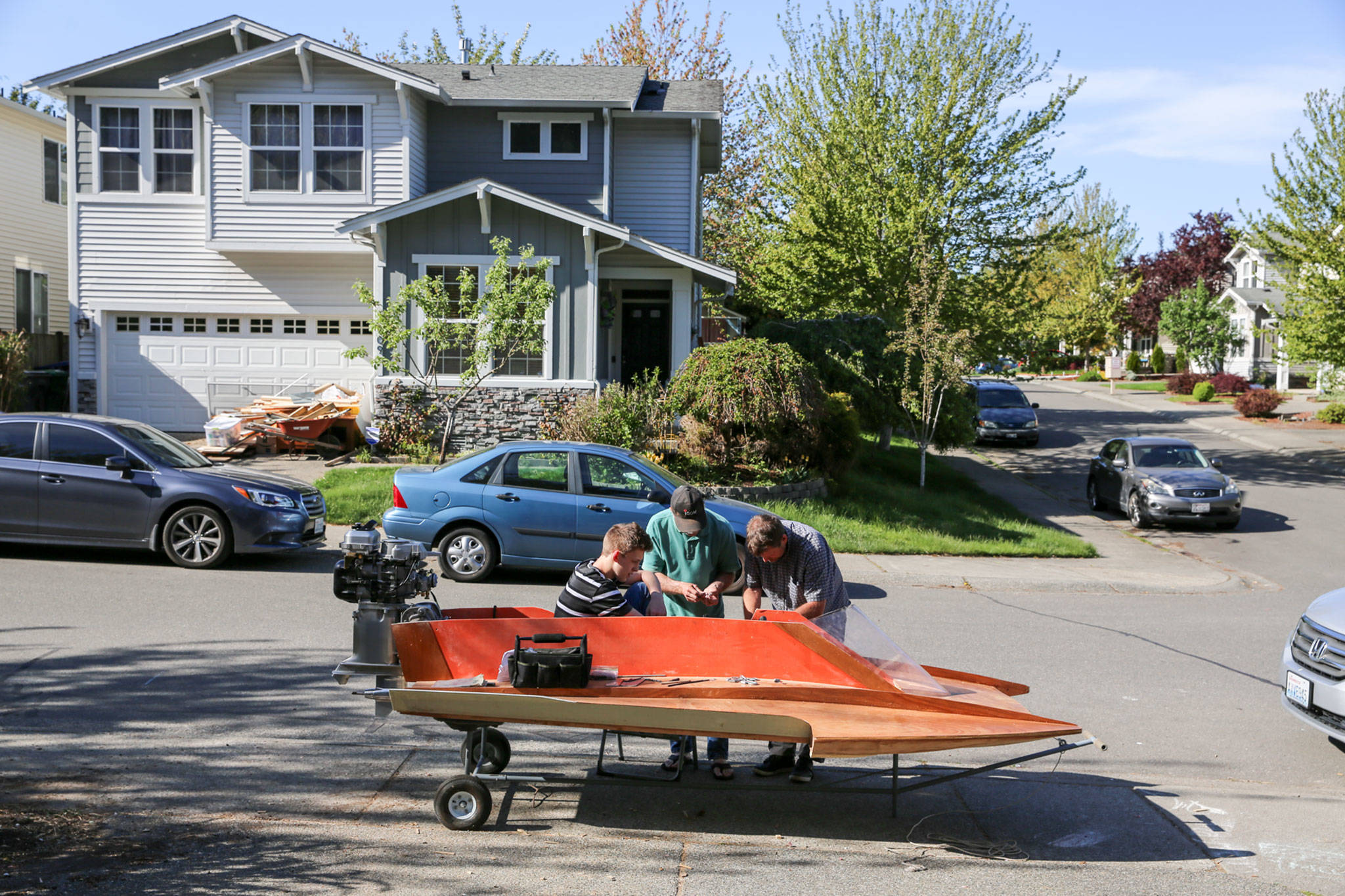 Peter Olesen (seated), Jim Tryon and Steve Olesen work to build Peter’s hydroplane Wednesday afternoon in Mill Creek. (Kevin Clark / The Herald)