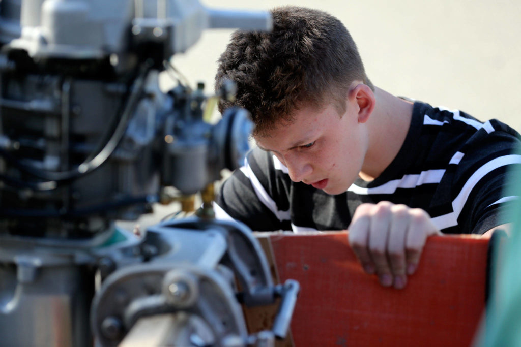 Peter Olesen mounts screws on his custom-built hydroplane Wednesday afternoon in Mill Creek. (Kevin Clark / The Herald)
