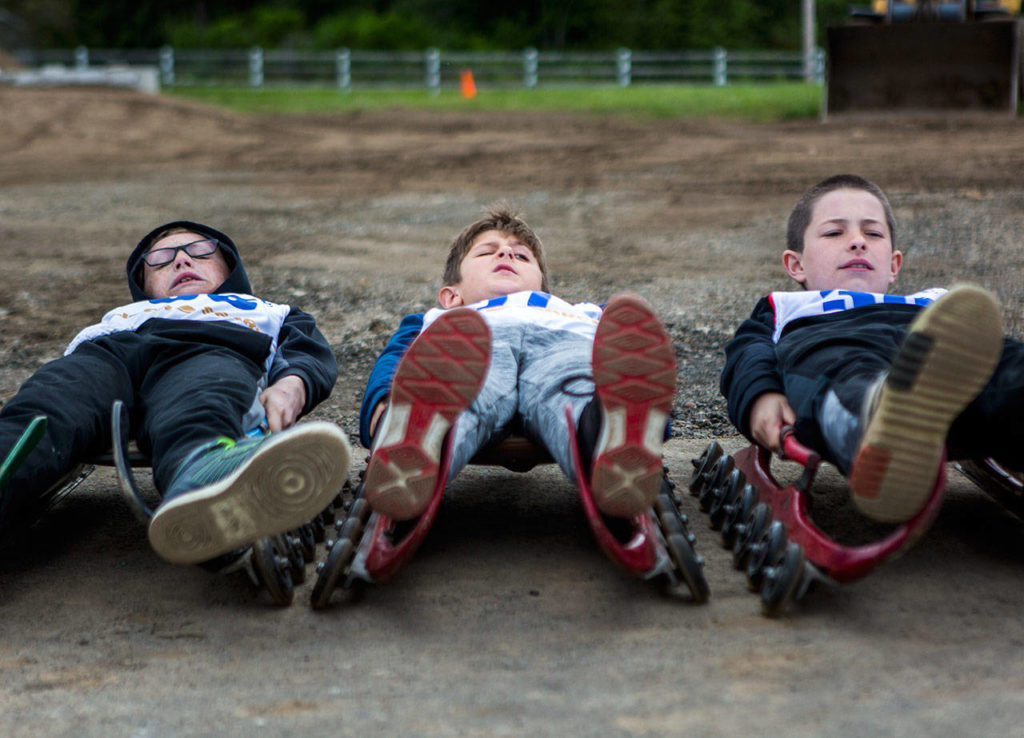 Kuper Stoner, left, Lawson Trout, center, and Reese Delaney, right, all practice their turning techniques during the USA Luge Slider Search program Sunday at Arrowhead Ranch on Camano Island. (Olivia Vanni / The Herald)
