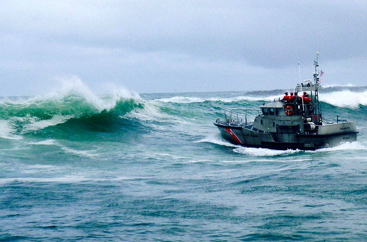 A U.S. Coast Guard boat crew responds to three fishermen in the water after the commercial fishing vessel Mary B II capsized while crossing Yaquina Bay Bar off the coast of Newport, Oregon, on Jan. 8. The U.S. Coast Guard is holding a public hearing Monday n Newport to review its handling of a crab boast sinking that killed 3 crabbers off the Oregon coast earlier this year. (U.S. Coast Guard via AP, File)