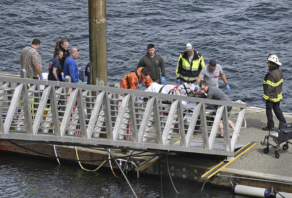 Emergency response crews transport an injured passenger to an ambulance at the George Inlet Lodge docks Monday in Ketchikan, Alaska. The passenger was from one of two float planes reported down in George Inlet early Monday afternoon and was dropped off by a U.S. Coast Guard 45-foot response boat. (Dustin Safranek/Ketchikan Daily News via AP)
