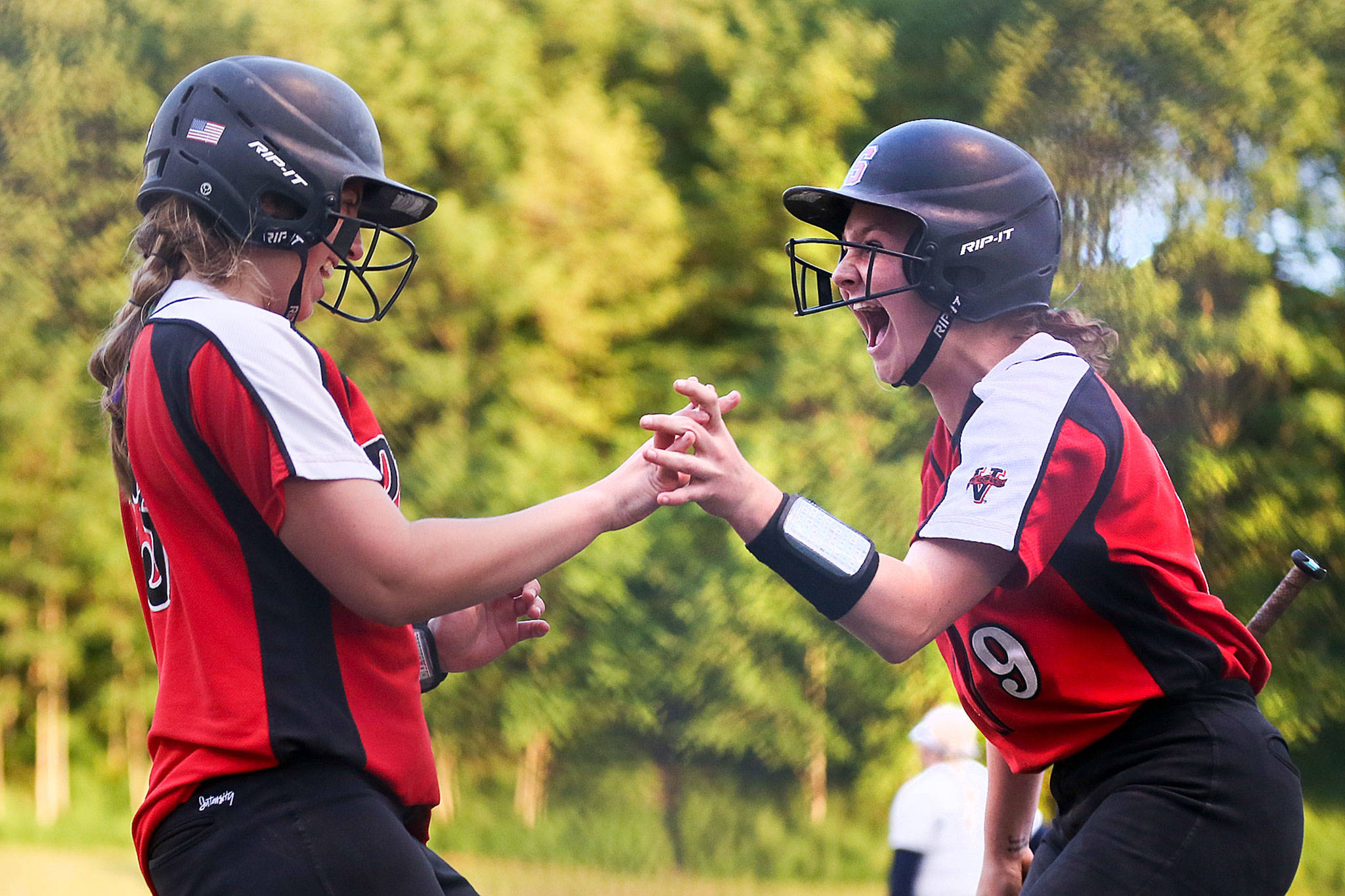 Snohomish’s Sydney Sandifer (left) and Janell Williams celebrate a run against Everett during a district playoff game on May 14, 2019, at Phil Johnson Ballfields in Everett. (Kevin Clark / The Herald)