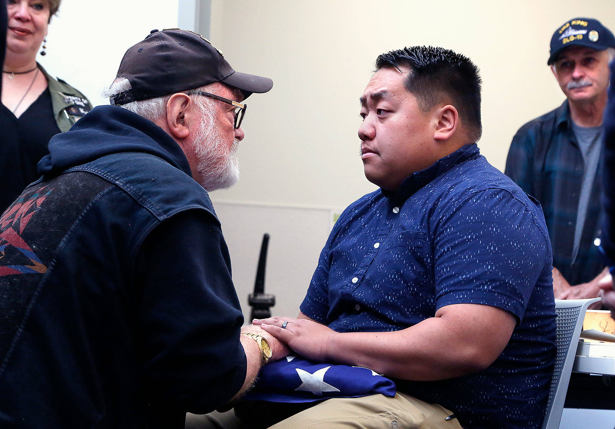 Marine Corps veteran Michael Reagan, creator of the Fallen Heroes Project, presents a folded American flag to Yee Hang Vang Tuesday in honor of Vang’s uncle, Say Chao Thao, who served in the CIA’s secret army in Laos during the Vietnam War. (Dan Bates / The Herald)
