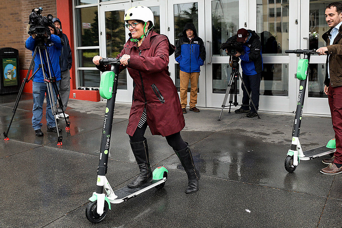 Mayor Cassie Franklin pushes off her first ride Friday morning during a launch event for an e-scooter pilot program. (Lizz Giordano / The Herald)