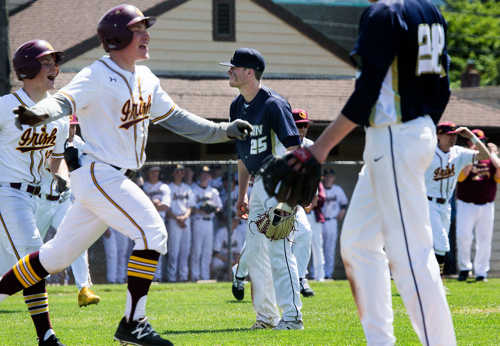 Arlington’s Cameron Smith (25) walks off the field as O’Dea players celebrate their 7-6 win in a Class 3A state regional Saturday at Sherman Anderson Field in Mount Vernon. The Eagles’ victory-filled season ended with the walk-off loss. (Andy Bronson / The Herald)