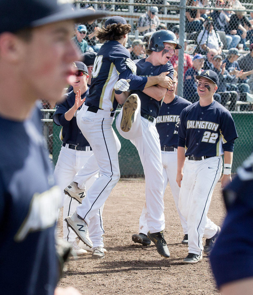 Arlington’s Cole Cramer (center) is lifted by a teammate after scoring during the Eagles’ fourth-inning outburst. (Andy Bronson / The Herald)
