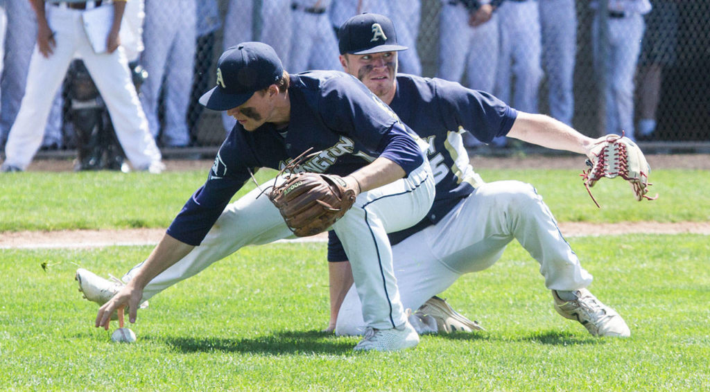 Arlington’s Camdon Anderson reaches for the ball, with pitcher Cameron Smith looking on. (Andy Bronson / The Herald)
