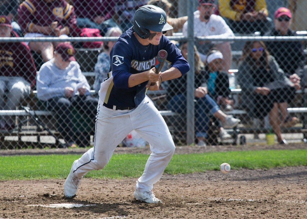 Arlington’s Camdon Anderson lays down a bunt single. (Andy Bronson / The Herald)
