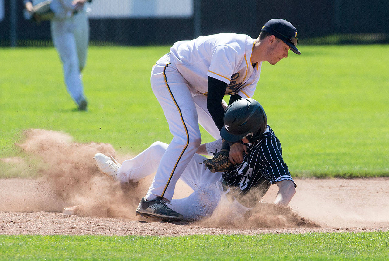 Everett’s Jonathan Murphy (left) tags out Peninsula’s Hunter Payne during the Seagulls’ 6-2 loss in a Class 3A state regional Saturday at Sherman Anderson Field in Mount Vernon. Everett’s milestone-filled season ended with the defeat. (Andy Bronson / The Herald)