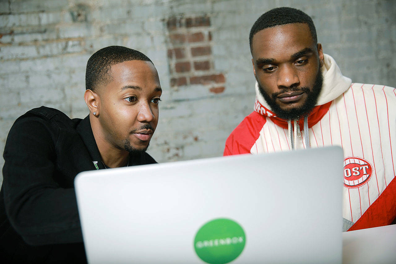 Business partners Ethan Jackson (left) and Andrew Farrior check emails before a meeting April 26 in Atlanta. As an aspiring marijuana businessman in New York, Farrior is following the marijuana legalization debate and its talk of social equity. He and he and co-founder Jackson are plowing ahead with plans to launch Greenbox. NYC as a subscription and delivery business for hemp and other legal cannabis-related products. (AP Photo/Elijah Nouvelage)