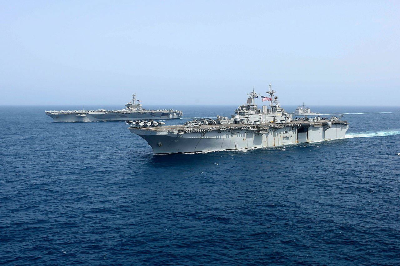 the amphibious assault ship USS Kearsarge sails in front of the USS Abraham Lincoln aircraft carrier Friday in the Arabian Sea. Commercial airliners flying over the Persian Gulf risk being targeted by “miscalculation or misidentification” from the Iranian military amid heightened tensions between the Islamic Republic and the U.S., American diplomats warned Saturday, May 18, 2019, even as both Washington and Tehran say they don’t seek war. (Mass Communication Specialist 1st Class Brian M. Wilbur, U.S. Navy via AP)