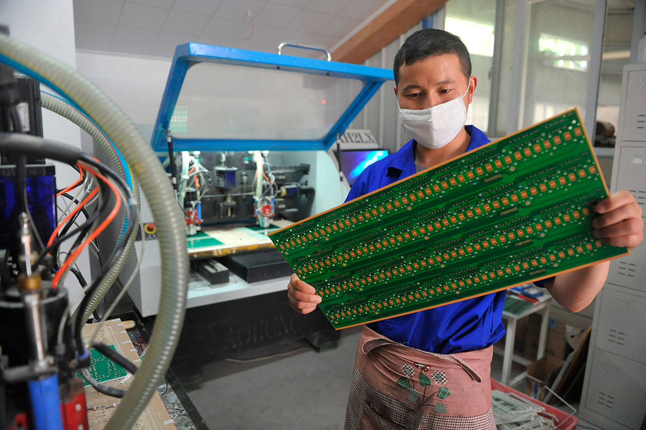 A staff member works in a circuit board manufacturing facility May 22 in Hangzhou in eastern China’s Zhejiang province. In a report issued Monday, a business group says the number of foreign companies in China that feel compelled to hand over technology in exchange for market access has doubled since two years ago. (Chinatopix via AP, File)
