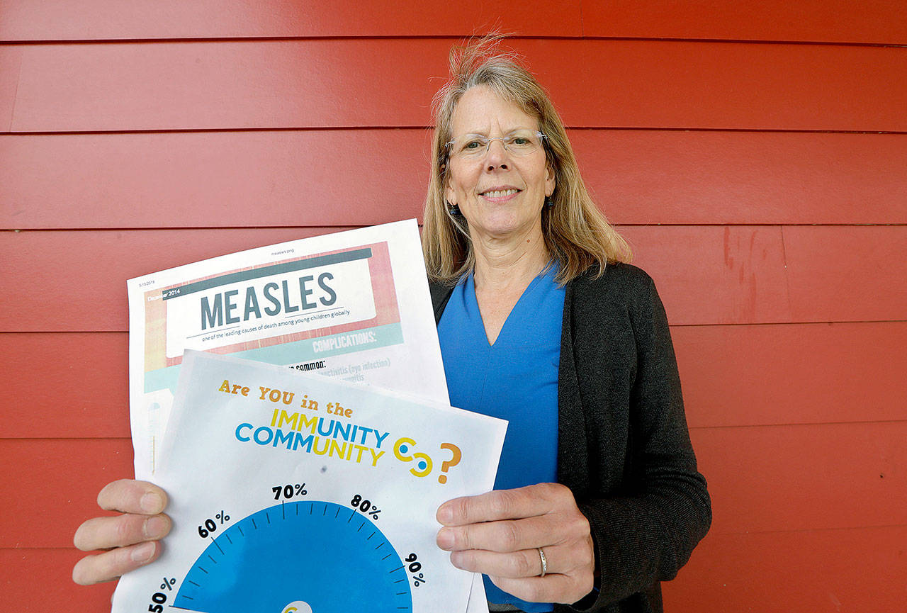 Vashon Island High School nurse Sarah Day holds information about measles vaccinations. (AP Photo/Elaine Thompson)