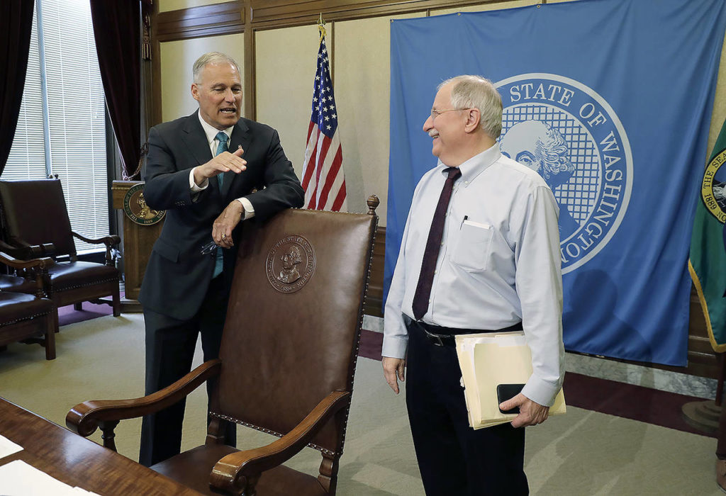 Washington Gov. Jay Inslee (left) talks with House Speaker Frank Chopp, D-Seattle (right), after Inslee signed the state operating budget Tuesday. (AP Photo/Ted S. Warren)
