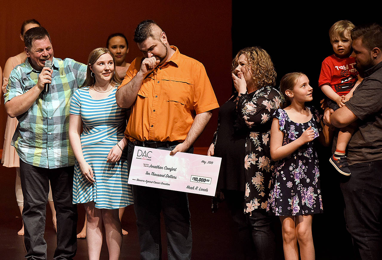 Len Wiens (left) presents a $10,000 check to the Comfort family — (from left) Kaelyn, 18, Jonathan, Ann Marie, Abigail, 10, Zander, 3, and Damon, 22 — at the Reflections School of Dance’s Celebrate Life benefit recital. The next Reflections event is June 8. (Madison Wiens / Reflections School of Dance)