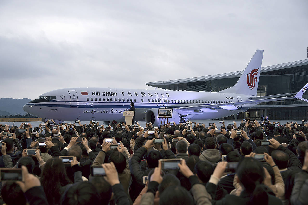 In this 2018 photo, invited guests take photos of the Boeing 737 Max 8 airplane deliver to Air China during a ceremony at Boeing Zhoushan 737 Completion and Delivery Center in Zhoushan, east China’s Zhejiang Province. (Chinatopix via AP)