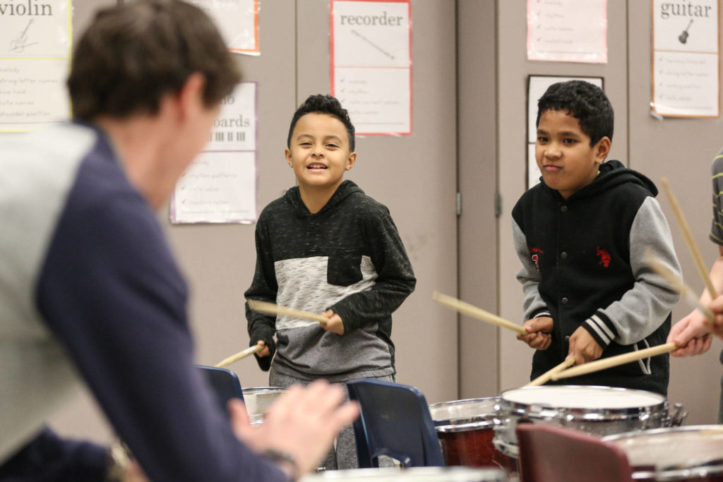Jayven Nation (center) and Milson Lain follow Pat Jameson’s lead during drum club practice at Challenger Elementary School in Everett. (Kevin Clark / The Herald)
