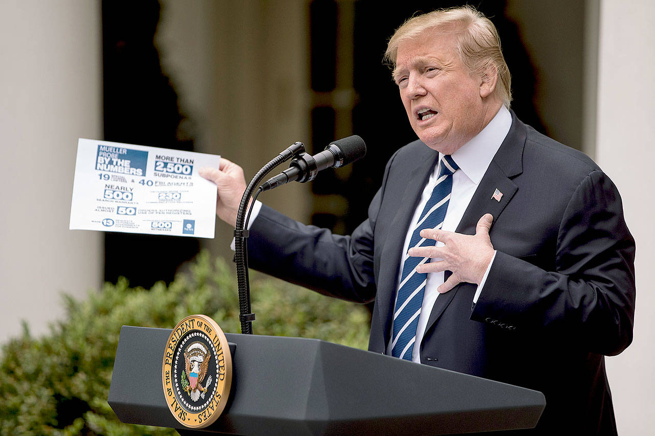 President Donald Trump holds up a stat sheet having to do with the Mueller report as he speaks in the Rose Garden at the White House in Washington on Wednesday. (AP Photo/Andrew Harnik)