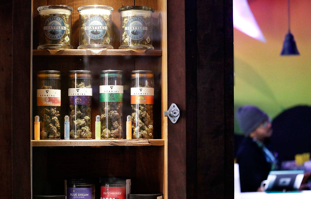 Marijuana products line a locked cabinet at a marijuana shop in Seattle in March. When Washington and Colorado launched their marijuana industries in the face of U.S. government prohibition, they imposed strict rules in hopes of keeping the U.S. Justice Department at bay. Five years later, federal authorities have stayed away, but the industry says it has been stifled by over-regulation. Lawmakers in both states have heard the complaints and are moving to ease the rules. (Elaine Thompson / Associated Press file photo)