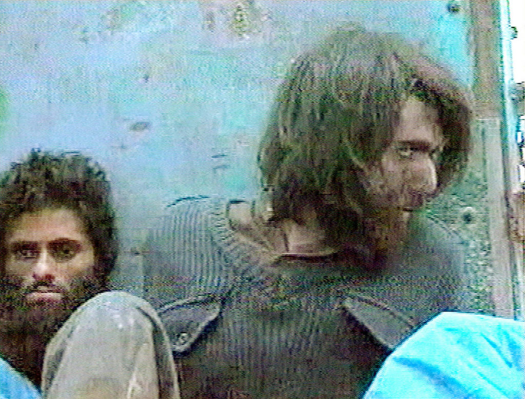 This image taken Dec. 1, 2001, from television footage in Mazar-i-Sharif, Afghanistan, shows John Walker Lindh (right) claiming to be an American Taliban volunteer. (AP Video, File)
