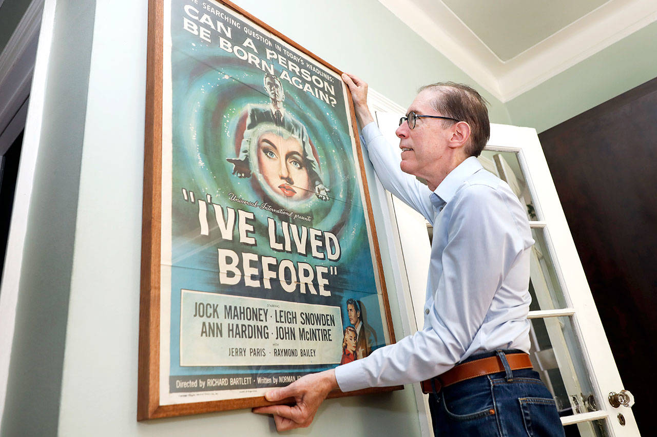 Kevin Kusinitz, a 63-year-old New Yorker who spent years being rejected from jobs for which he felt overqualified following an August 2012 layoff, straightens one of his old movie poster collection, in his apartment on New York’s Upper East Side, Wednesday. About half of Americans think there’s age discrimination in the workplace, according to a new poll by The Associated Press-NORC Center for Public Affairs Research. (AP Photo/Richard Drew)