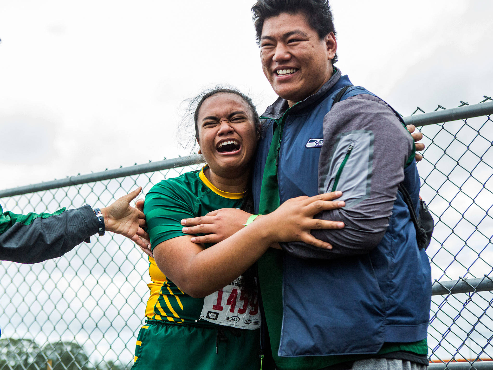 Shorecrest’s Kiana Lino cries while hugging her coach Mingure Dorjee after winning the 3A girls shot put Friday at the 4A/3A/2A State Track Field Championships at Mount Tahoma High School. Lino’s winning throw of 44 feet 10 inches was a personal best. (Olivia Vanni / The Herald)