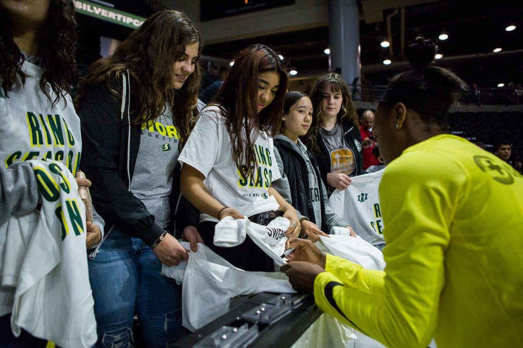 Seattle Storm’s Jewell Loyd signs fan’s t-shirts before the start of the season opener game against the Phoenix Mercury on Saturday, May 25, 2019 in Everett, Wash. (Olivia Vanni / The Herald)
