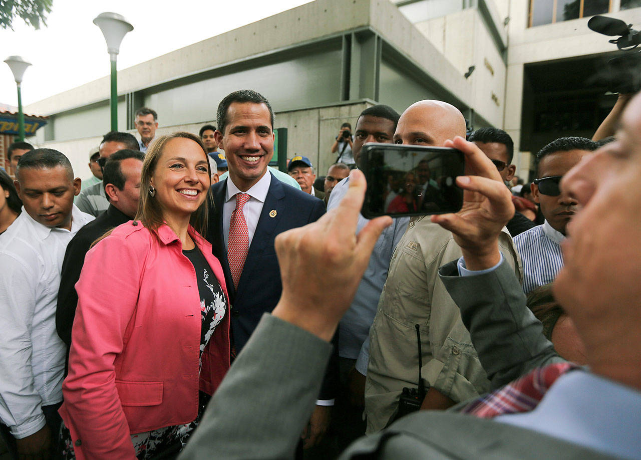 Venezuela’s opposition leader and self-proclaimed interim president Juan Guaido poses for a selfie photo Friday with supporters after a meeting of “Plan Pais” or Country Plan at University Catholic Andres Bello in Caracas, Venezuela.(AP Photo/Fernando Llano)