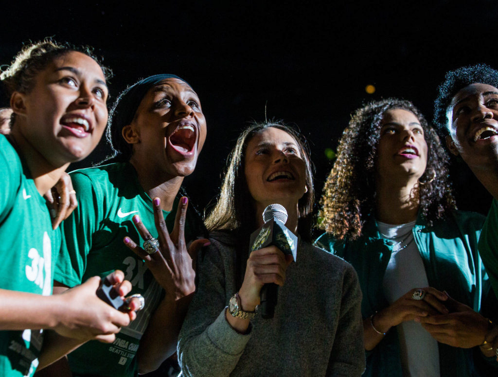 Seattle Storm’s Kaleena Mosqueda-Lewis, Crystal Langhorne, Sue Bird, Alysha Clark, and Natasha Howard react to their championship banner being revealed during the ring ceremony before the season opener game against the Phoenix Mercury on Saturday, May 25, 2019 in Everett, Wash. (Olivia Vanni / The Herald)
