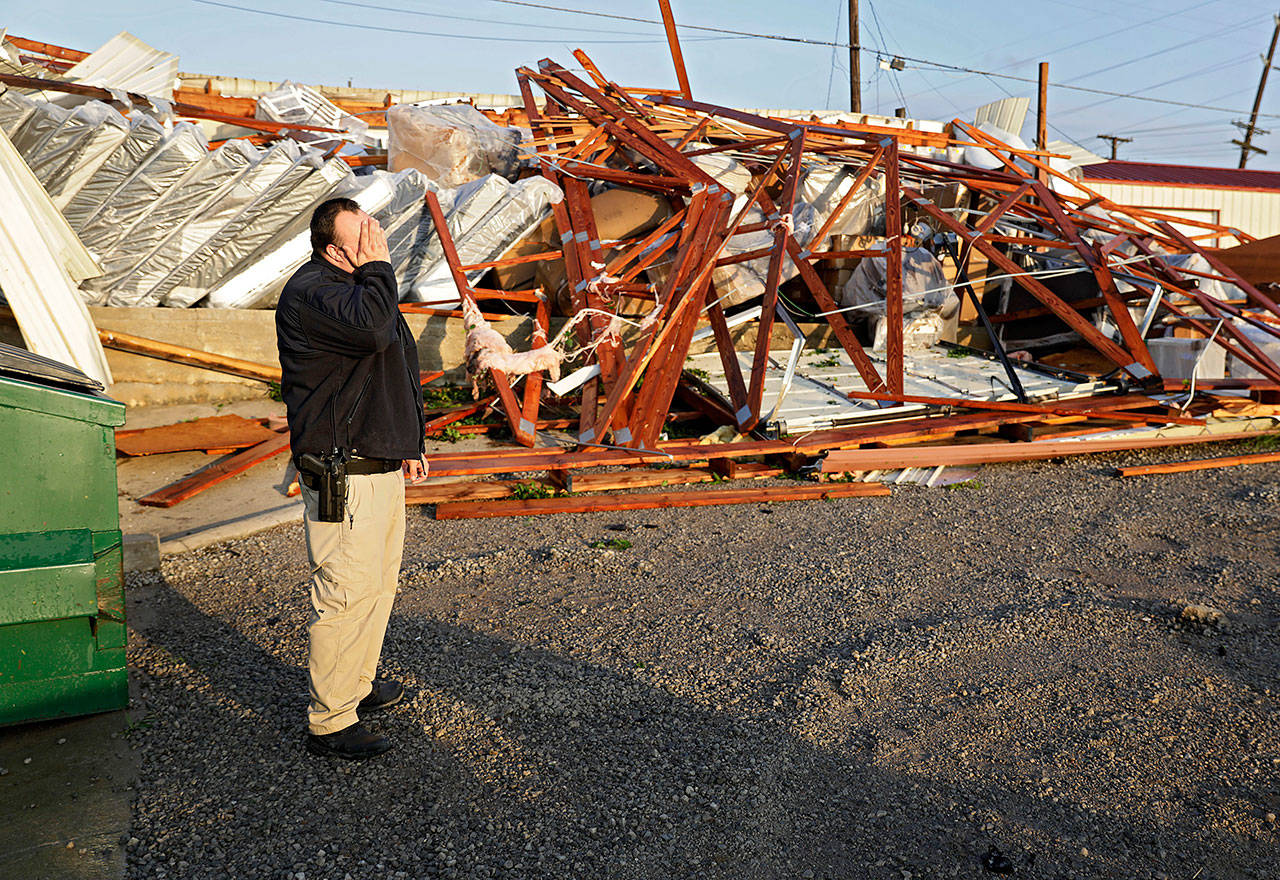 Justin Sloggett reacts while talking about his parents furniture store, The Saving Place Rustic Furniture and Mattress, after a suspected tornado destroyed their warehouse in Sapulpa, Oklahoma. early Sunday. Sloggett was keeping an eye on the store at sunrise. (Mike Simons/Tulsa World via AP)