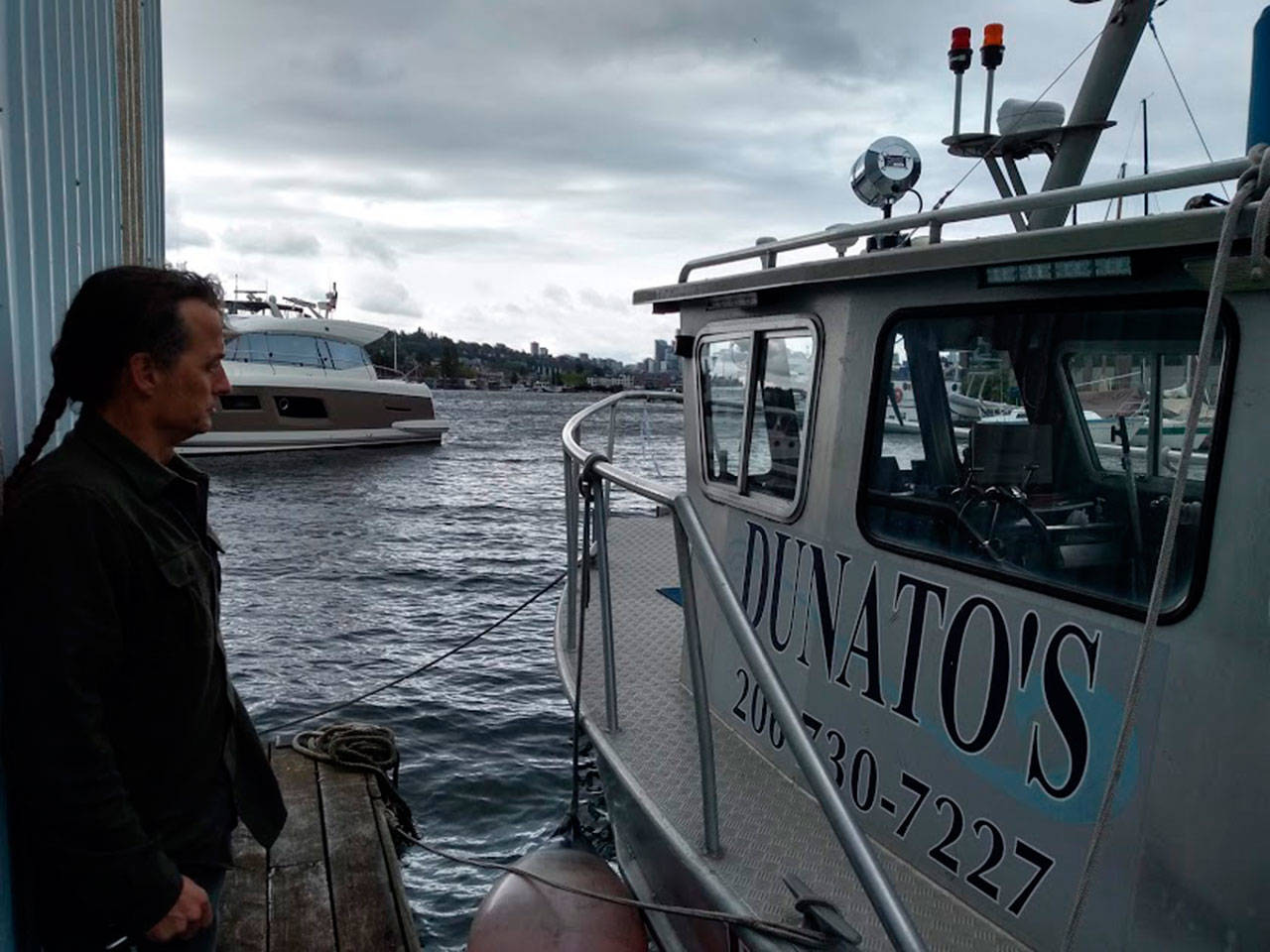 Corey Breuer, owner of Northwest Boat Disposal at Dunato’s Boat Yard in Seattle shows a reporter one of three vessels which can lift sunken boats from King County waters and Puget Sound. (Aaron Kunkler / King County reporter)