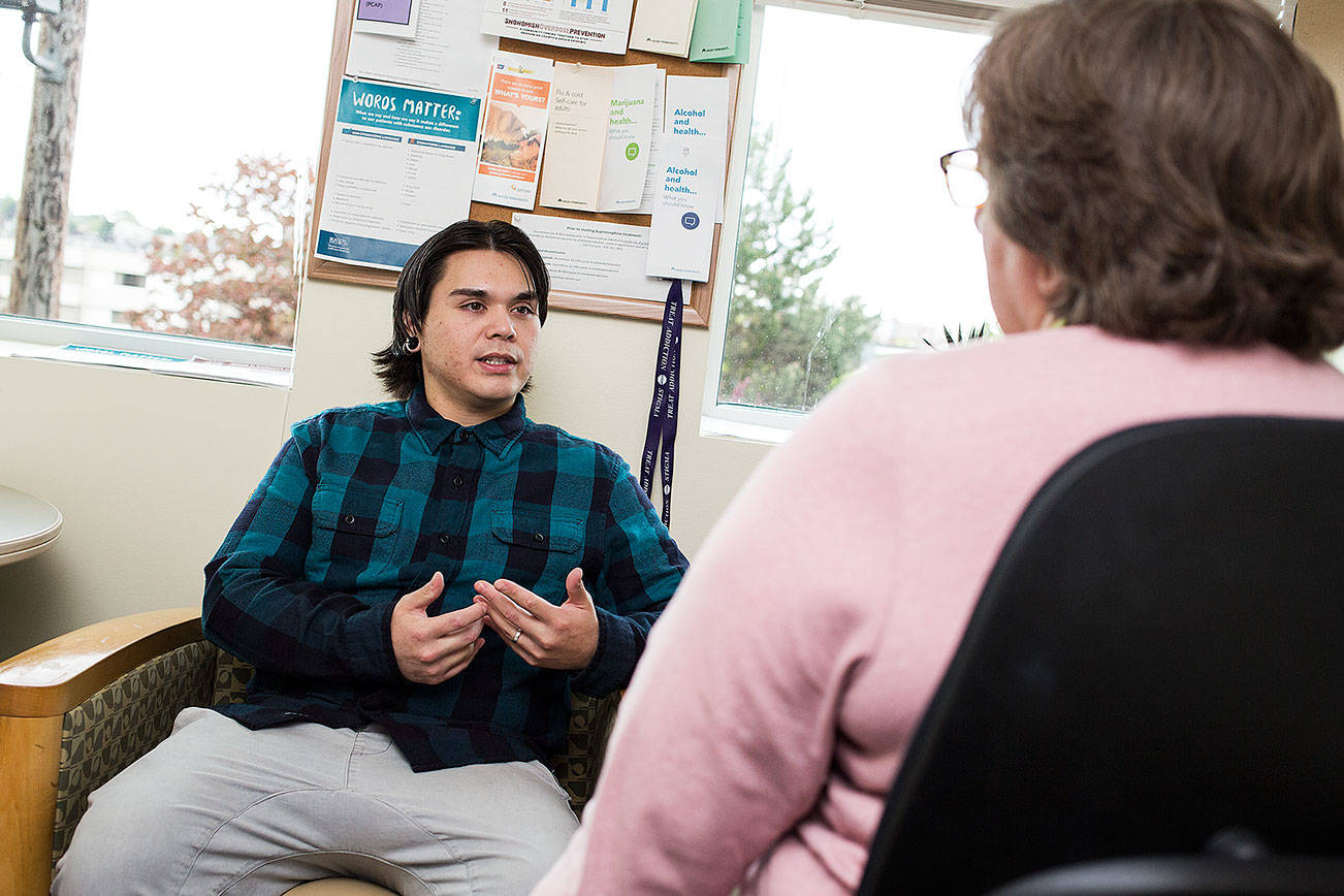 Kaiser Permanente nurse Eileen Krembs talks with patient John Haws, who is receiving in-office opiate addiction treatment in Everett. (Andy Bronson / The Herald)
