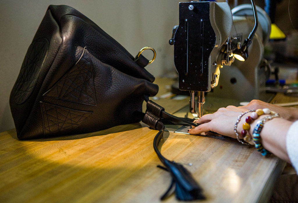 Madeline Chadwick works on the strap of a bucket bag. (Olivia Vanni / The Herald)
