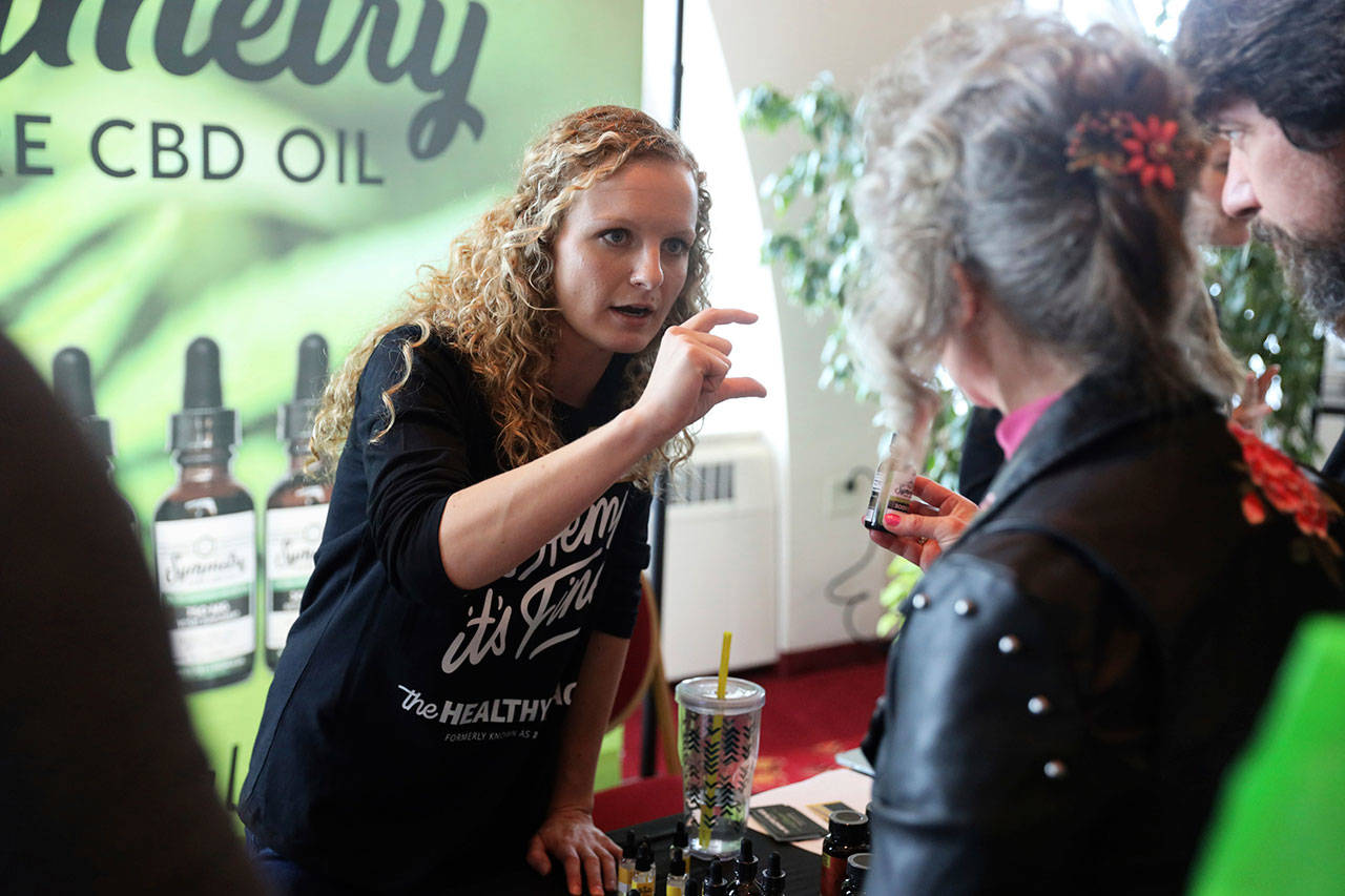 Lindsey Bouras (left), wellness consultant at The Healthy Place, talks to an attendee about CBD oil at the It’s Hemp, It’s Fine event, April 7, at Monona Terrace Convention Center in Madison, Wisconsin. The event featured a panel discussion, informational booths, and free samples of CBD coffee, beer, kombucha, candy and more. (Coburn Dukehart / Wisconsin Center for Investigative Journalism)