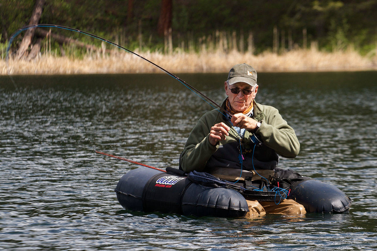 Chuck Morrison plays a trout that grabbed his fly at Black Pine Lake near Twisp. (Mike Benbow photo)