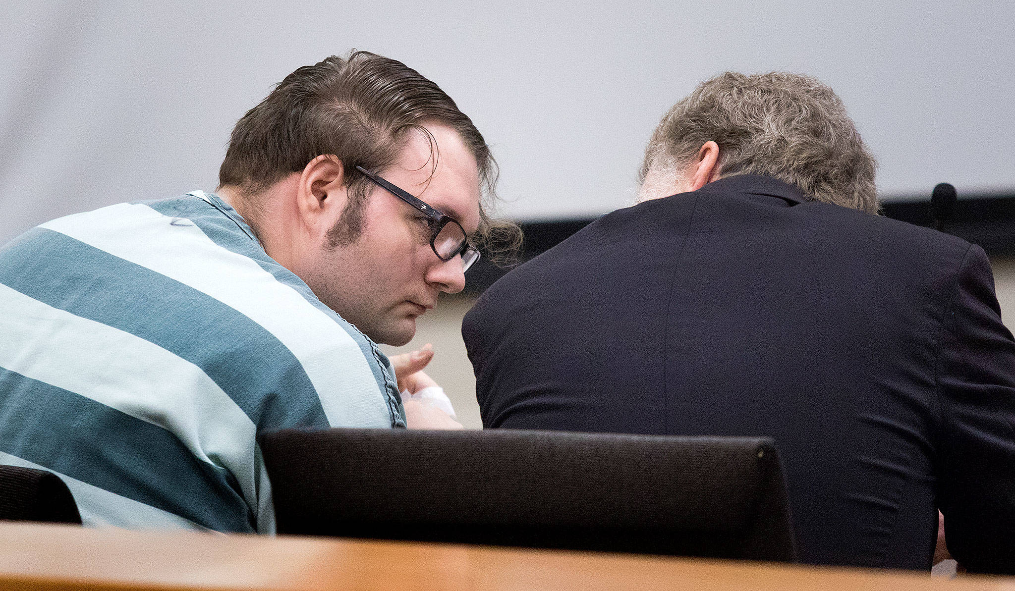 Dakota Reed consults with his attorney before he is sentenced to a year in jail at Snohomish County Courthouse on Tuesday in Everett. Reed had pleaded guilty in May to two counts of threats to bomb or injure property and spewing violent speech on fake Facebook pages for months. (Andy Bronson / The Herald)