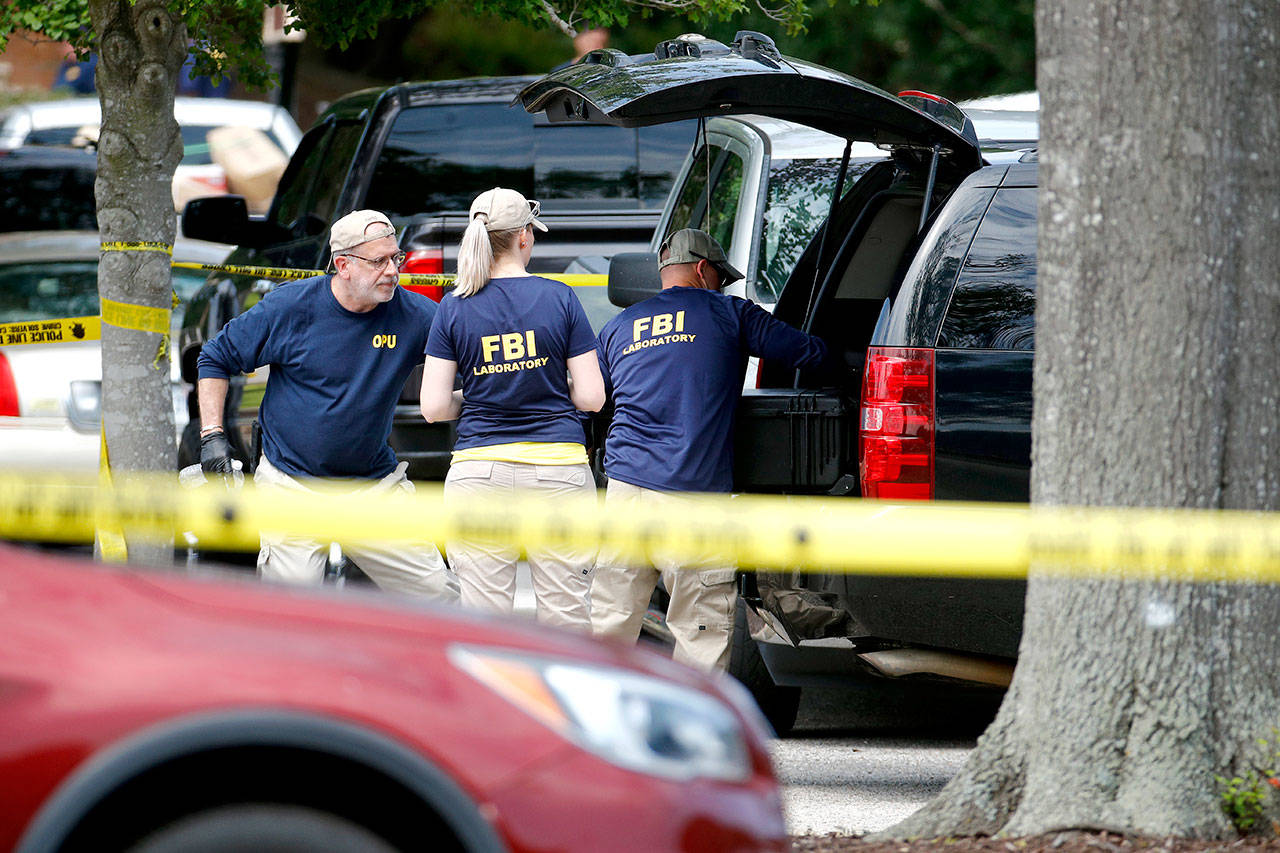 Members of the FBI load equipment into a vehicle Saturday as they work in a parking lot outside a municipal building that was the scene of a shooting in Virginia Beach, Virginia.(AP Photo/Patrick Semansky)