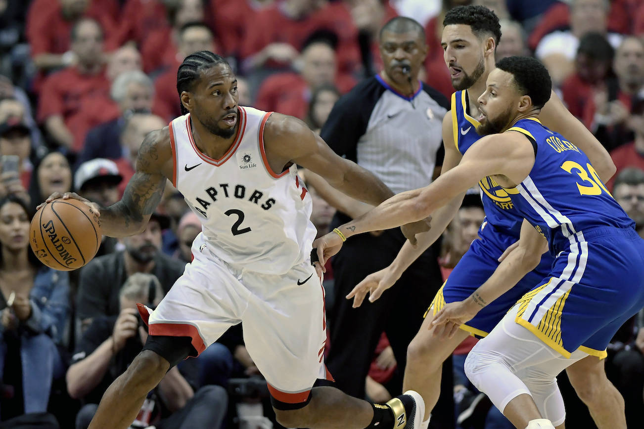 Toronto Raptors forward Kawhi Leonard (2) looks for a way out under pressure from Golden State Warriors guard Stephen Curry (30) and teammate Klay Thompson (11) during the first half of Game 2 of the NBA Finals in Toronto on Sunday, June 2, 2019. THE CANADIAN PRESS/Frank Gunn