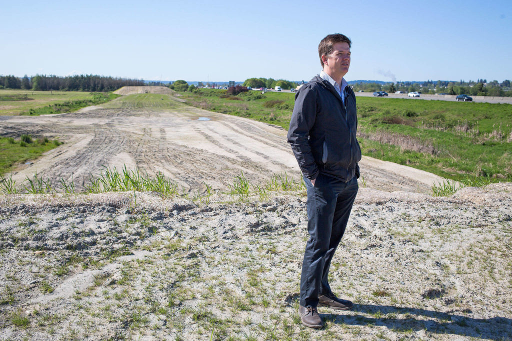 In April, Erik Gerking, the Port of Everett’s director of environmental programs, walks along the east side of I-5 where the Port of Everett, working with a private company, has been stockpiling clean fill dirt for a habitat project in the Snohomish River estuary. (Andy Bronson / The Herald)
