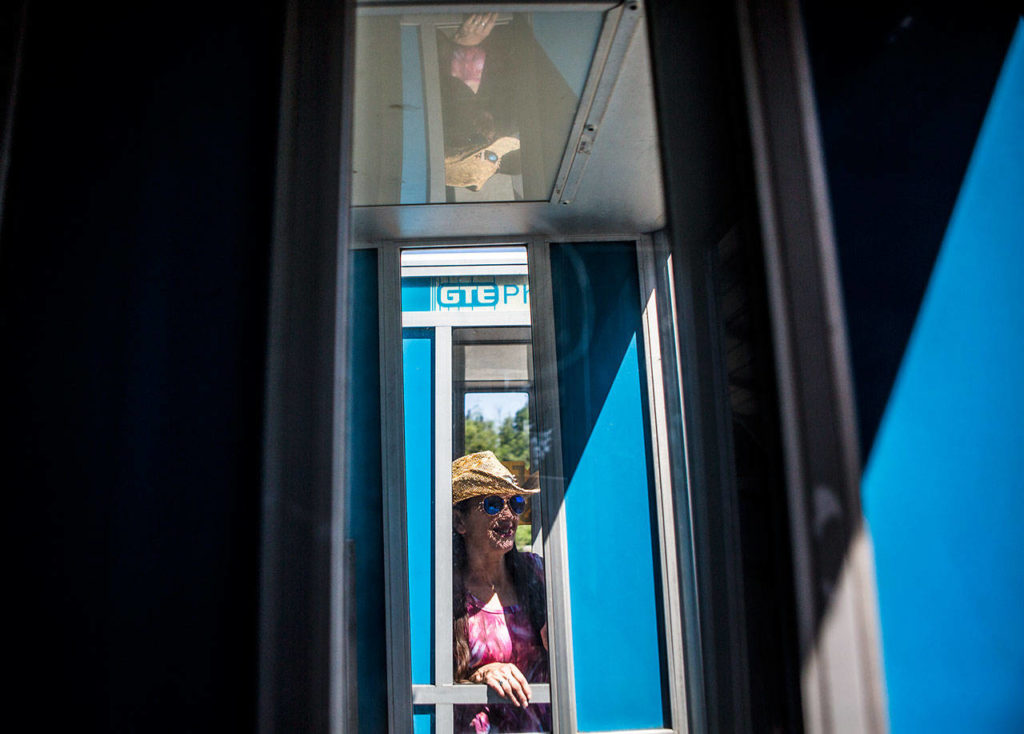 Store owner Cynthia Marie in one of her phone booths for sale. (Olivia Vanni / The Herald)
